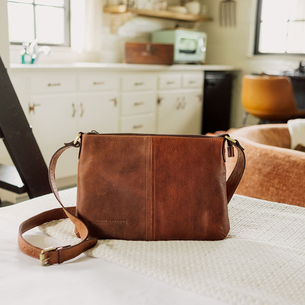 Brown leather handbag on a kitchen counter with blurred background