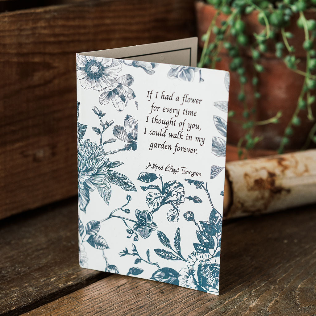 Floral card with text on a wooden surface with plants in the background