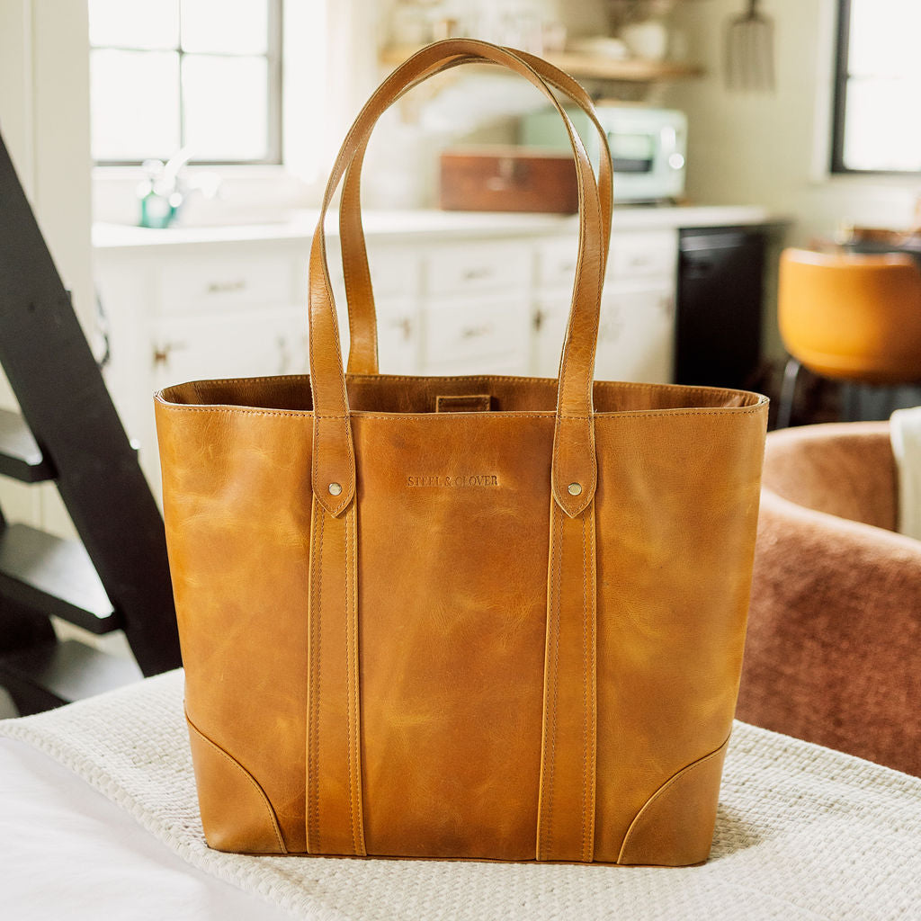 Brown leather tote bag on a table with a kitchen background