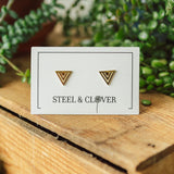 A pair of gold-plated, geometric triangle stud earrings on a presentation card that reads 'STEEL & CLOVER'.