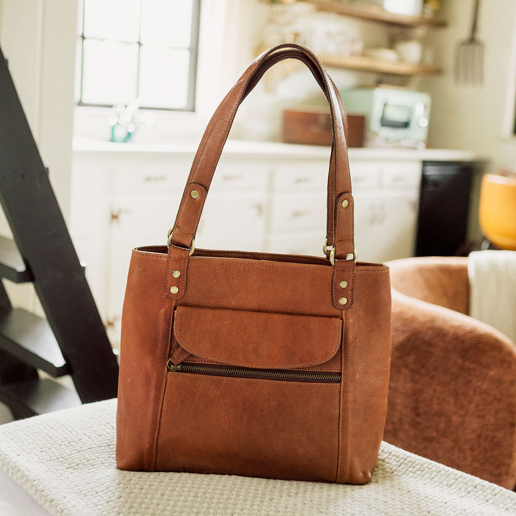 Brown leather handbag on a kitchen counter with a blurred background