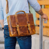 Person wearing a brown leather satchel bag outdoors